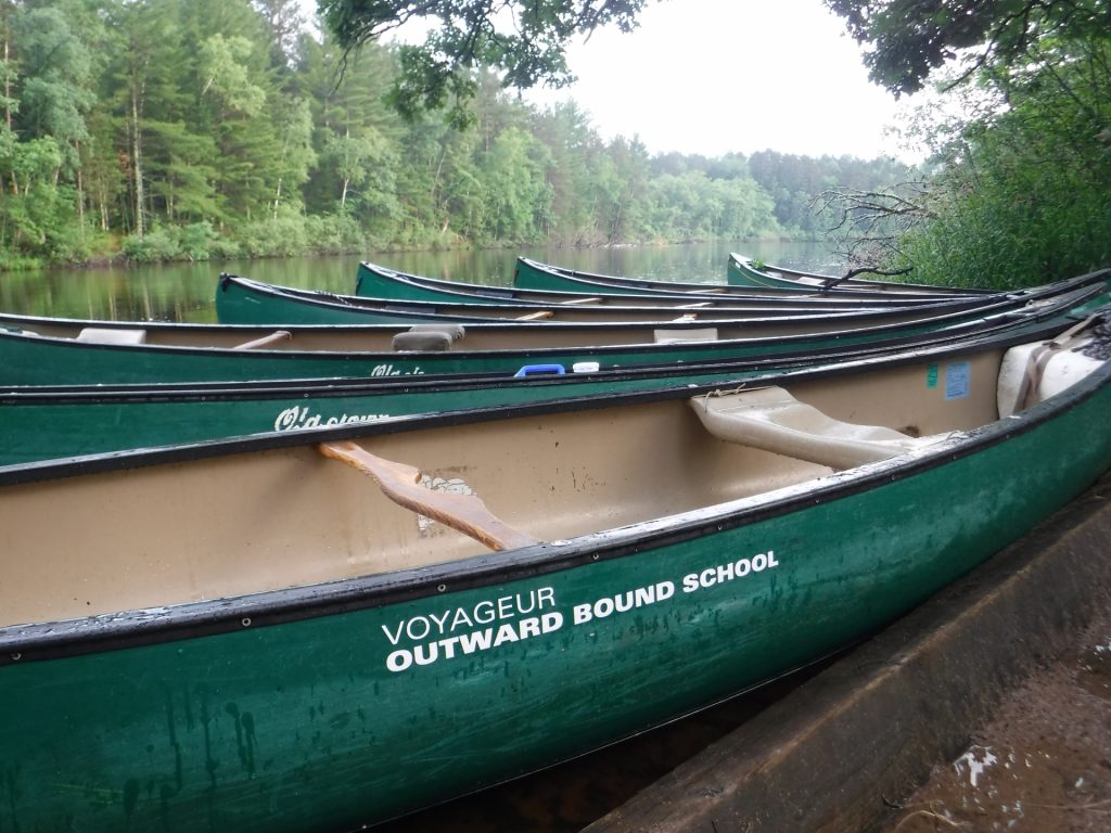 Voyageur canoes are tied up on the banks of the St. Croix River after a full day of travel. 